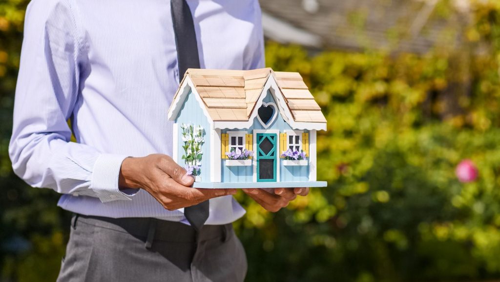 Person holding a model house